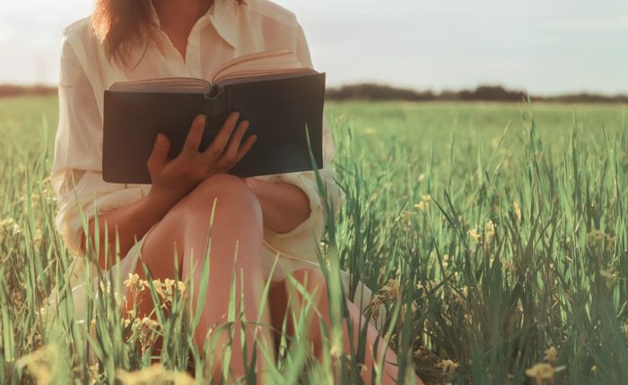 life after drug rehab - woman reading book in a field - Fair Oaks Recovery Center
