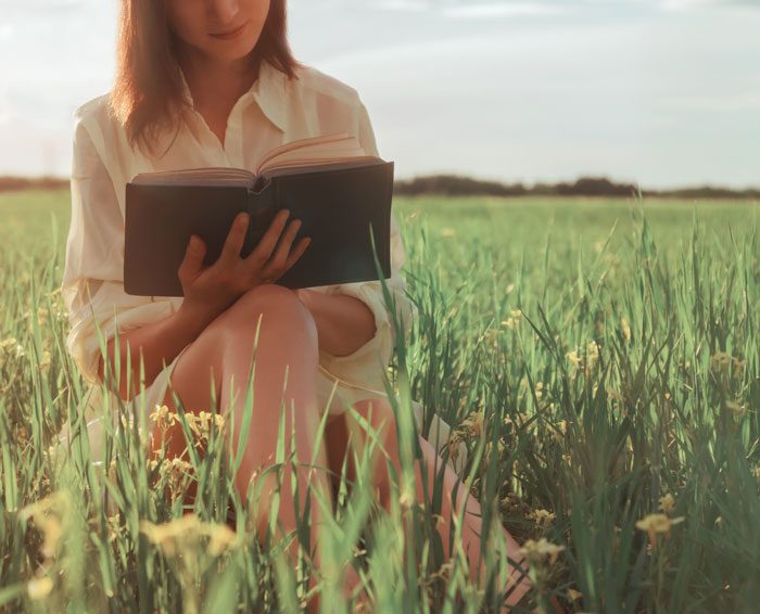 life after drug rehab - woman reading book in a field - Fair Oaks Recovery Center