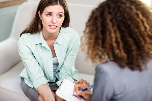 aftercare programs, The Importance of Continuing Care after Rehab - woman in therapists office