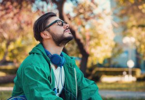 brunette bearded man with glasses in green coat taking deep breath outdoors - How to Treat Mental Illness Without Medication 