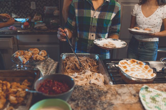 How to Explain Your Recovery to Relatives, buffet style family spread, with young man and woman making plates - your recovery